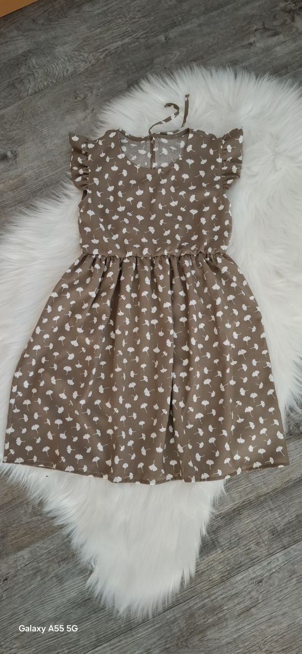 Mädchen Sommerkleid aus Bambus-Popeline in Taupe mit weißen Pusteblumen – Flügelärmel – nachhaltige Kinderkleidung.