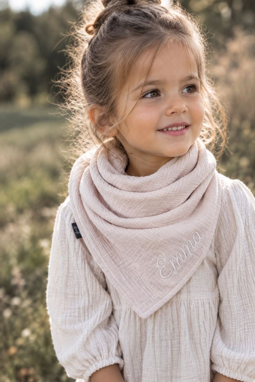 Kleines Mädchen mit personalisiertem Romazzi Musselin-Halstuch in Beige mit Namen Emma